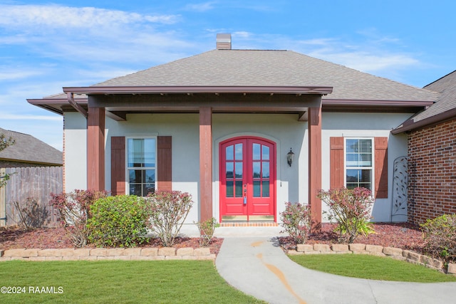 view of exterior entry with french doors and a yard