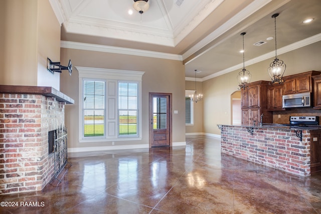 kitchen with ornamental molding, a kitchen bar, appliances with stainless steel finishes, and hanging light fixtures