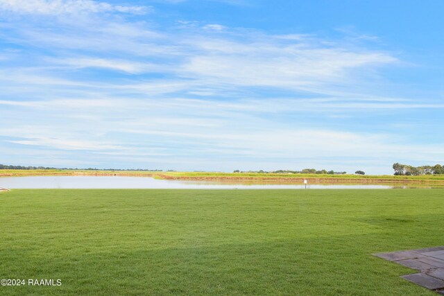 view of home's community with a lawn and a water view