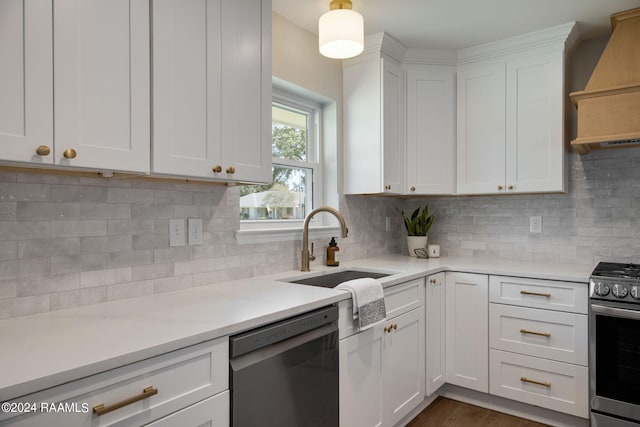 kitchen featuring black dishwasher, white cabinetry, custom range hood, decorative backsplash, and stainless steel range