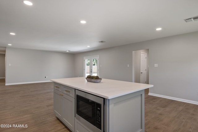 kitchen featuring a center island, dark hardwood / wood-style flooring, french doors, and built in microwave