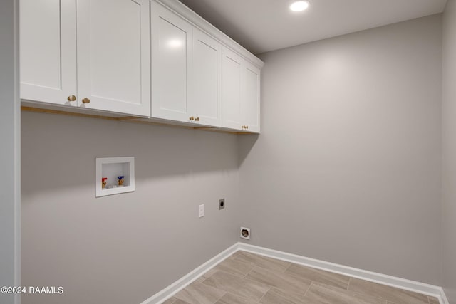 clothes washing area with washer hookup, cabinets, and electric dryer hookup