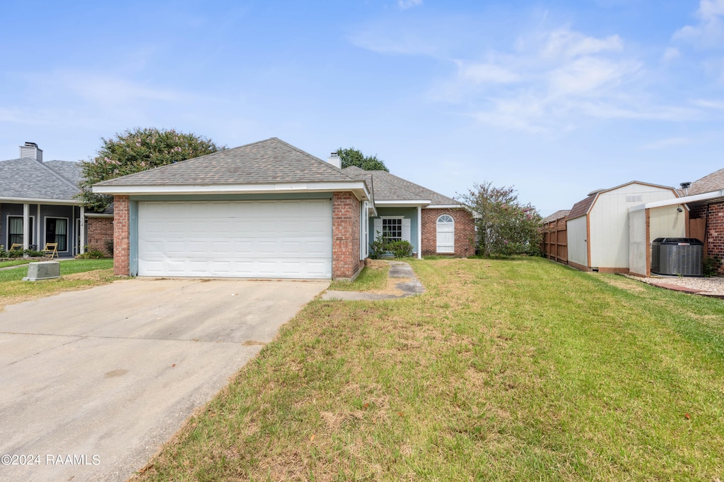 view of front facade with a garage, central AC unit, and a front yard