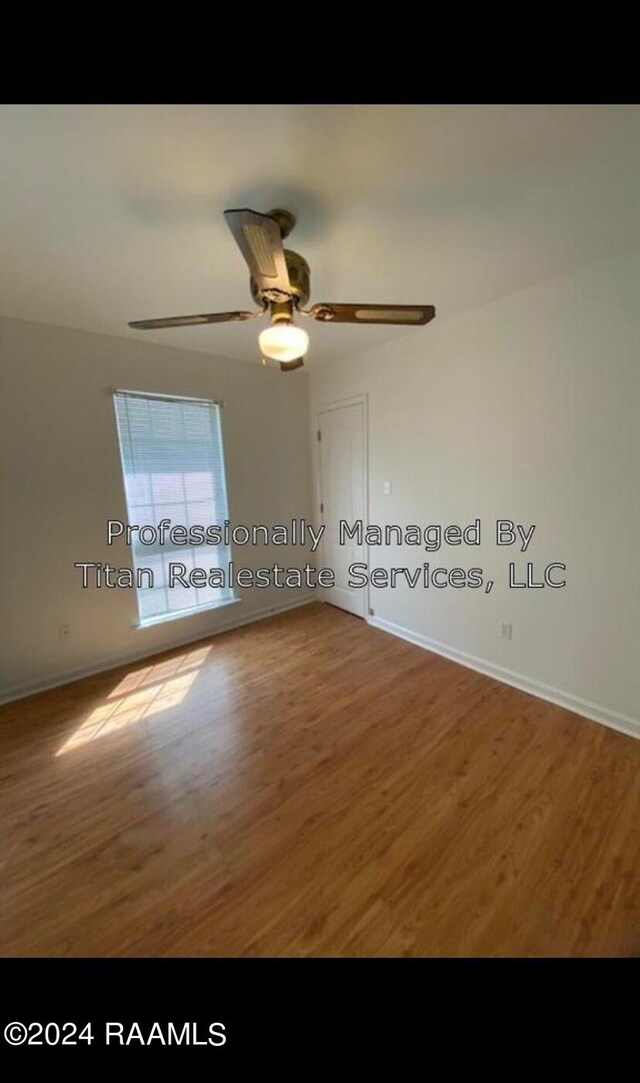 empty room featuring wood-type flooring and ceiling fan