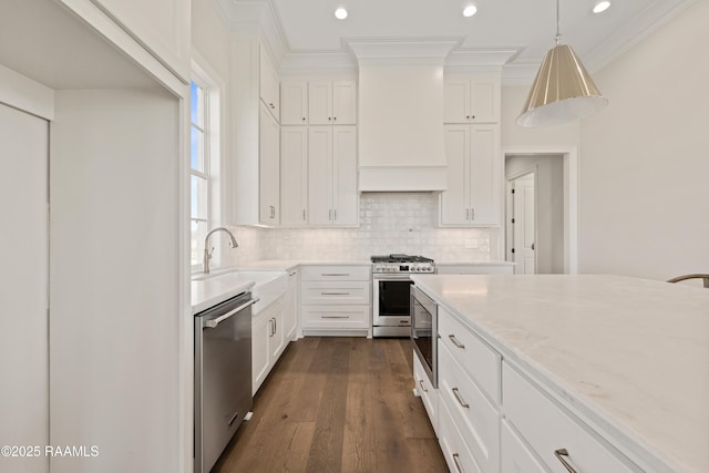 kitchen with stainless steel appliances, ornamental molding, backsplash, a sink, and dark wood-style floors