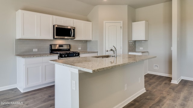 kitchen featuring tasteful backsplash, sink, an island with sink, white cabinets, and appliances with stainless steel finishes