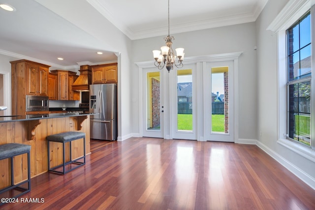 kitchen with stainless steel appliances, dark hardwood / wood-style floors, a healthy amount of sunlight, and a breakfast bar area