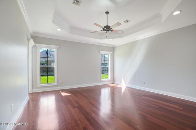 spare room with wood-type flooring, a raised ceiling, and ornamental molding