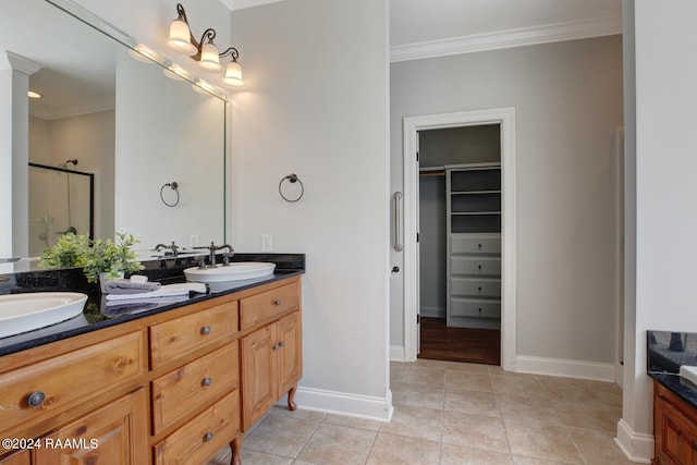 bathroom with vanity, crown molding, tile patterned flooring, and a shower with door