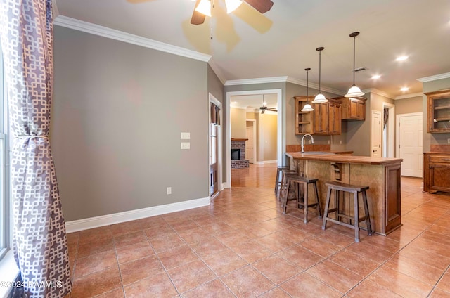 kitchen featuring crown molding, a breakfast bar area, and pendant lighting