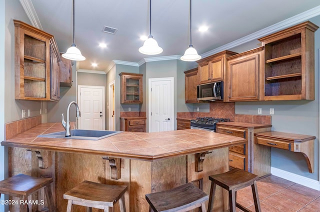 kitchen with hanging light fixtures, kitchen peninsula, a breakfast bar area, stainless steel appliances, and sink