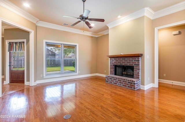 unfurnished living room featuring a brick fireplace, light hardwood / wood-style flooring, ornamental molding, and ceiling fan