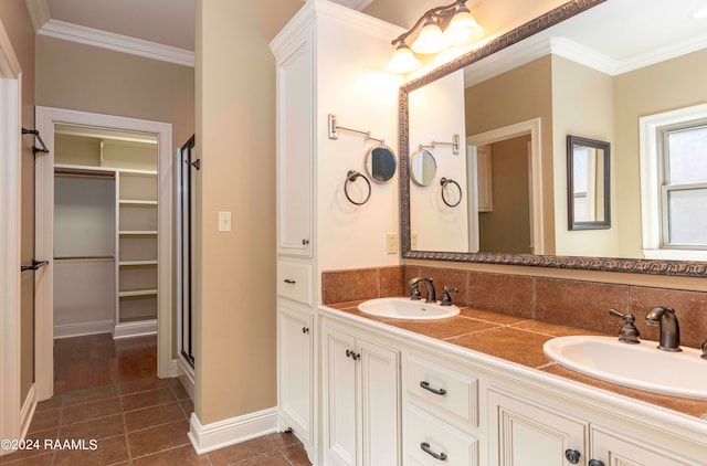 bathroom with vanity, tasteful backsplash, a shower with shower door, crown molding, and tile patterned flooring