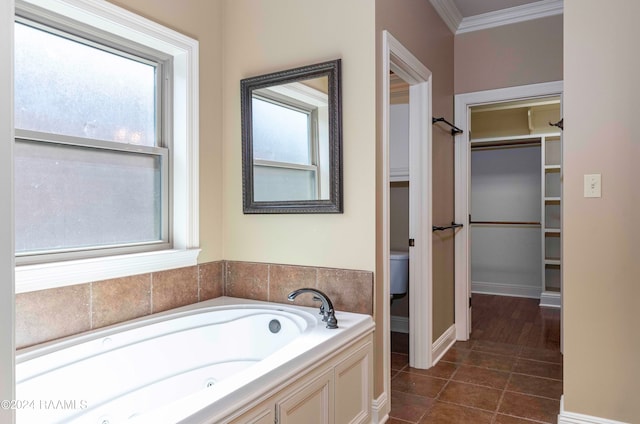 bathroom with ornamental molding, a tub to relax in, tile patterned flooring, and toilet