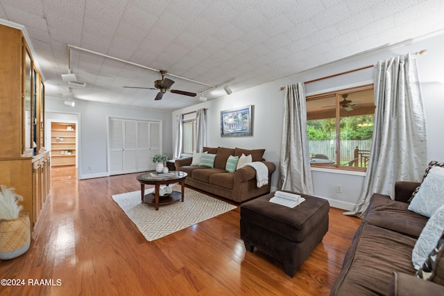 living room with wood-type flooring, rail lighting, and ceiling fan