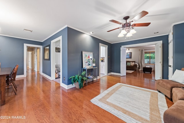 living room with crown molding, hardwood / wood-style floors, and ceiling fan