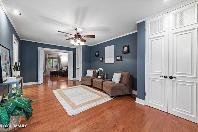 living room featuring light hardwood / wood-style floors, crown molding, and ceiling fan