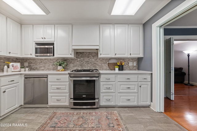 kitchen featuring backsplash, light hardwood / wood-style floors, stainless steel appliances, white cabinets, and ornamental molding