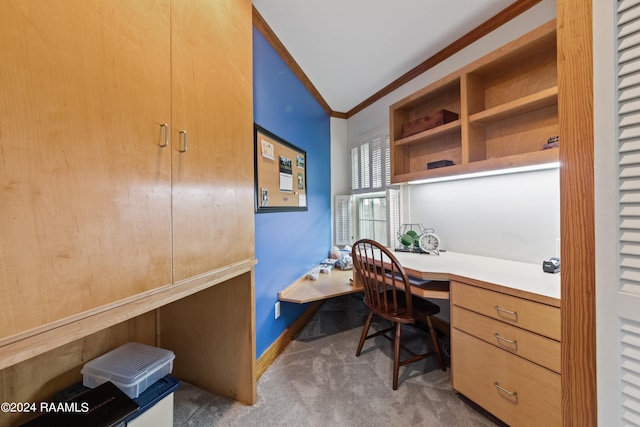 carpeted home office featuring built in desk, ornamental molding, and vaulted ceiling