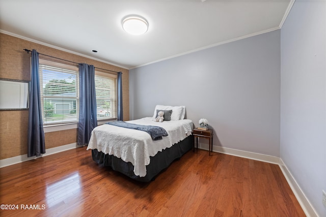 bedroom featuring ornamental molding and hardwood / wood-style floors