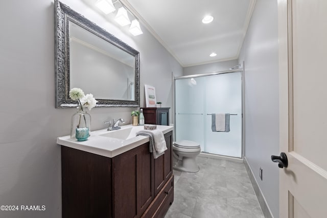 bathroom featuring vanity, toilet, ornamental molding, and a shower with door