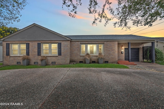 ranch-style home featuring a garage and a carport