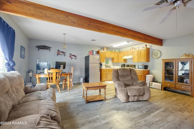 living room with ceiling fan, beamed ceiling, and light hardwood / wood-style flooring