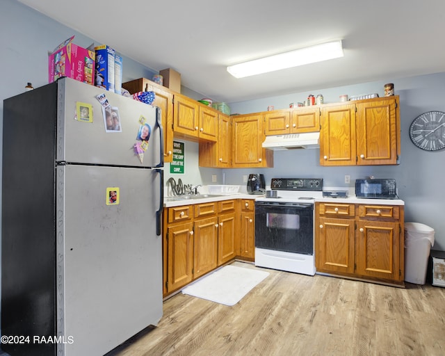 kitchen featuring stainless steel refrigerator, light hardwood / wood-style flooring, sink, and electric range