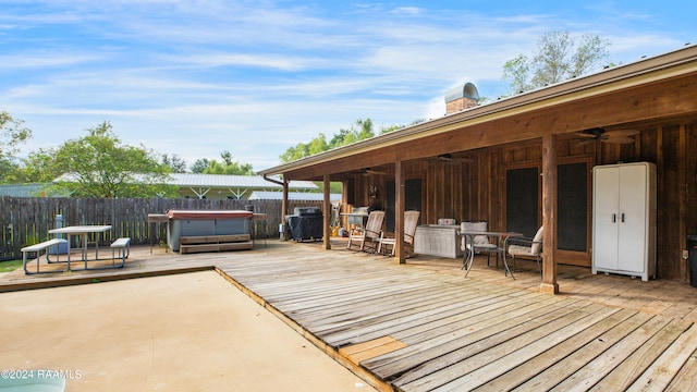 wooden deck featuring a hot tub, area for grilling, and ceiling fan