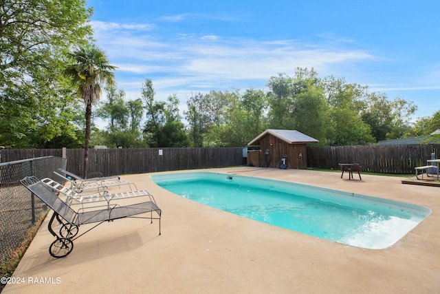 view of swimming pool featuring a storage unit and a patio