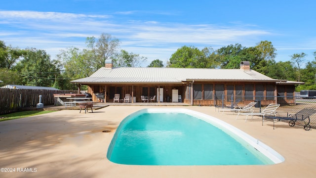 view of pool featuring a sunroom, a patio, and exterior bar