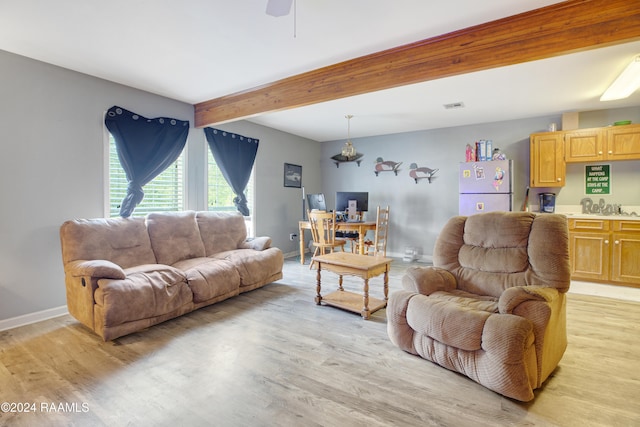 living room with ceiling fan, beamed ceiling, and light wood-type flooring