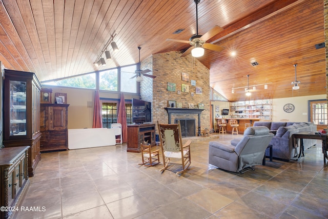 living room featuring rail lighting, high vaulted ceiling, a brick fireplace, ceiling fan, and wooden ceiling