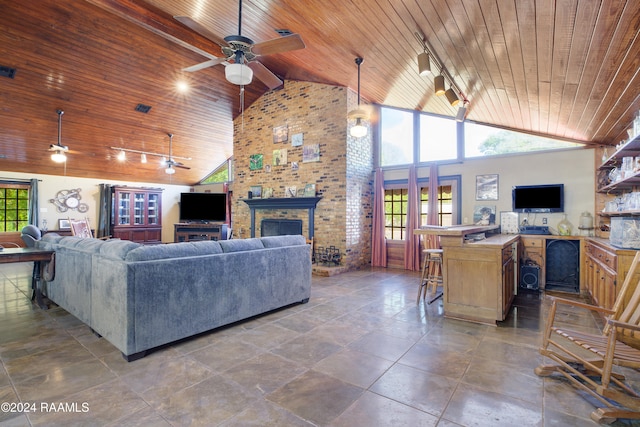 living room featuring wood ceiling, a fireplace, high vaulted ceiling, and plenty of natural light