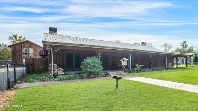 rear view of property featuring a lawn