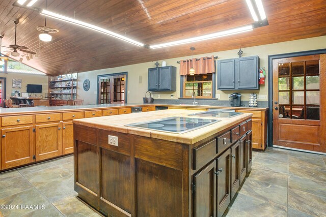 kitchen featuring stovetop, kitchen peninsula, wooden ceiling, and sink