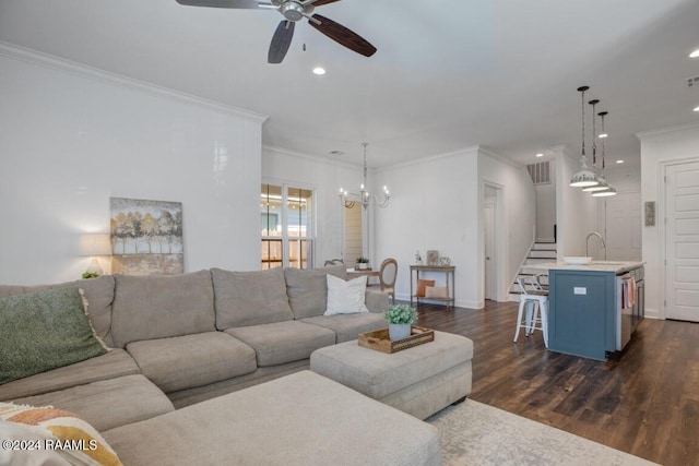 living room featuring sink, ceiling fan with notable chandelier, crown molding, and dark wood-type flooring