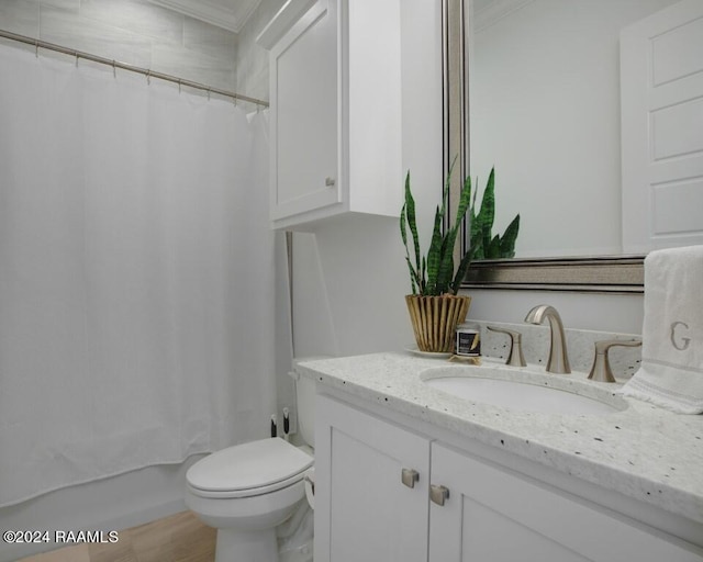 full bathroom with shower / bathtub combination with curtain, hardwood / wood-style floors, ornamental molding, vanity, and toilet