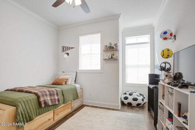 bedroom featuring ceiling fan, hardwood / wood-style flooring, ornamental molding, and multiple windows