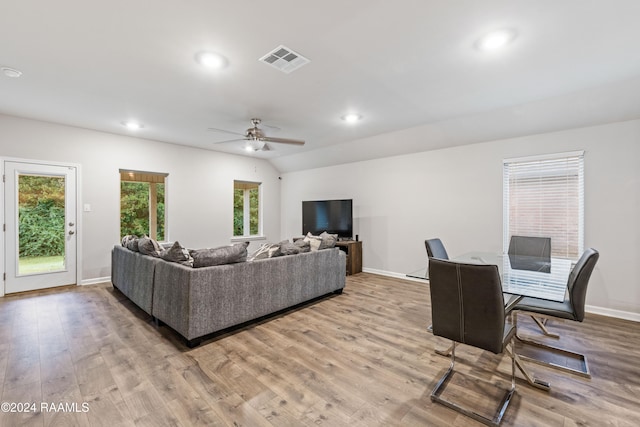 living room featuring light hardwood / wood-style floors, ceiling fan, and vaulted ceiling