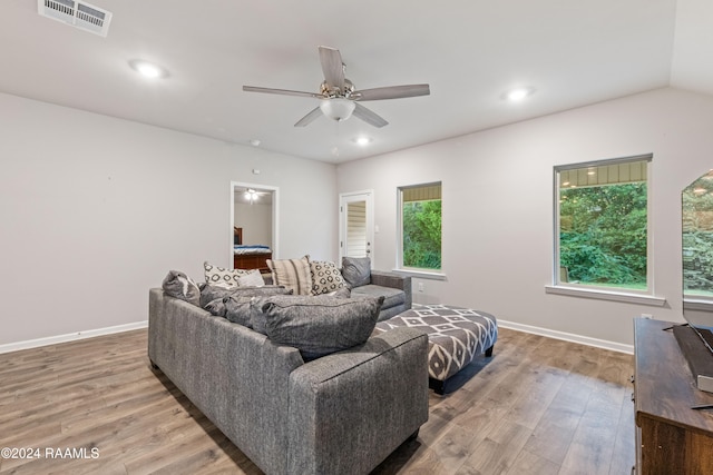 living room with hardwood / wood-style floors, ceiling fan, and vaulted ceiling