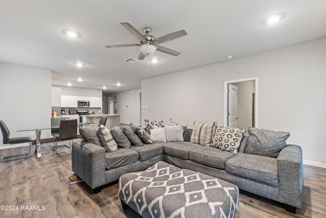 living room with light hardwood / wood-style floors and ceiling fan