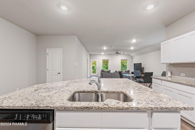 kitchen featuring sink, light stone counters, ceiling fan, and white cabinets