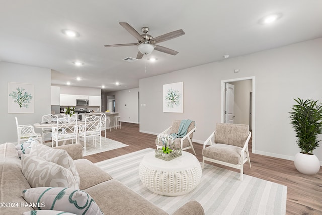 living room with light wood-type flooring and ceiling fan