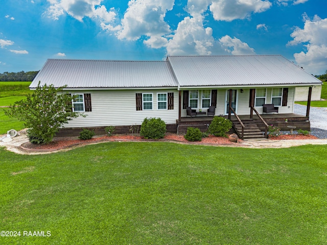 view of front of home featuring covered porch, metal roof, and a front lawn