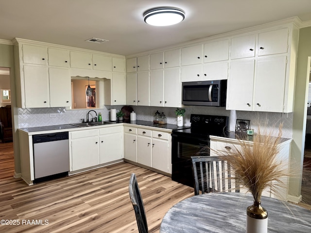 kitchen featuring visible vents, light wood-style flooring, a sink, appliances with stainless steel finishes, and white cabinetry