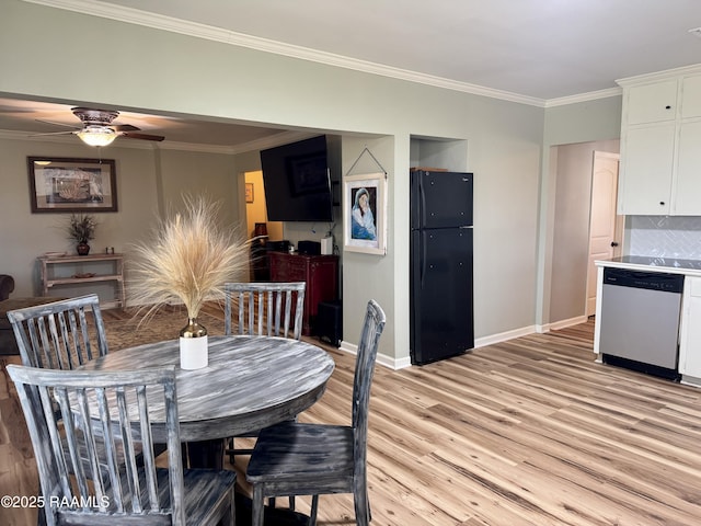 dining room featuring light wood-type flooring, baseboards, ornamental molding, and a ceiling fan