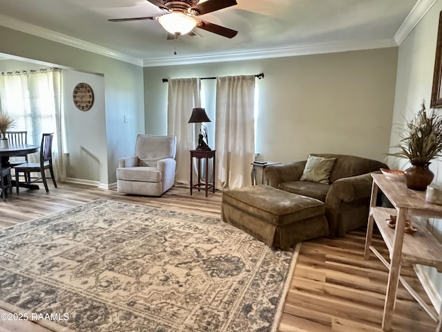 living area featuring light wood-type flooring and crown molding