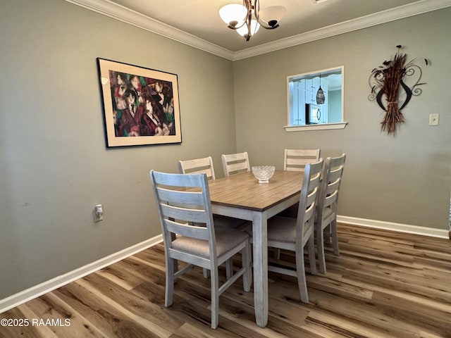 dining area with an inviting chandelier, wood finished floors, baseboards, and ornamental molding