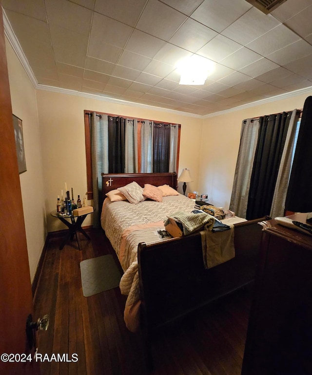 bedroom featuring ornamental molding and dark wood-type flooring